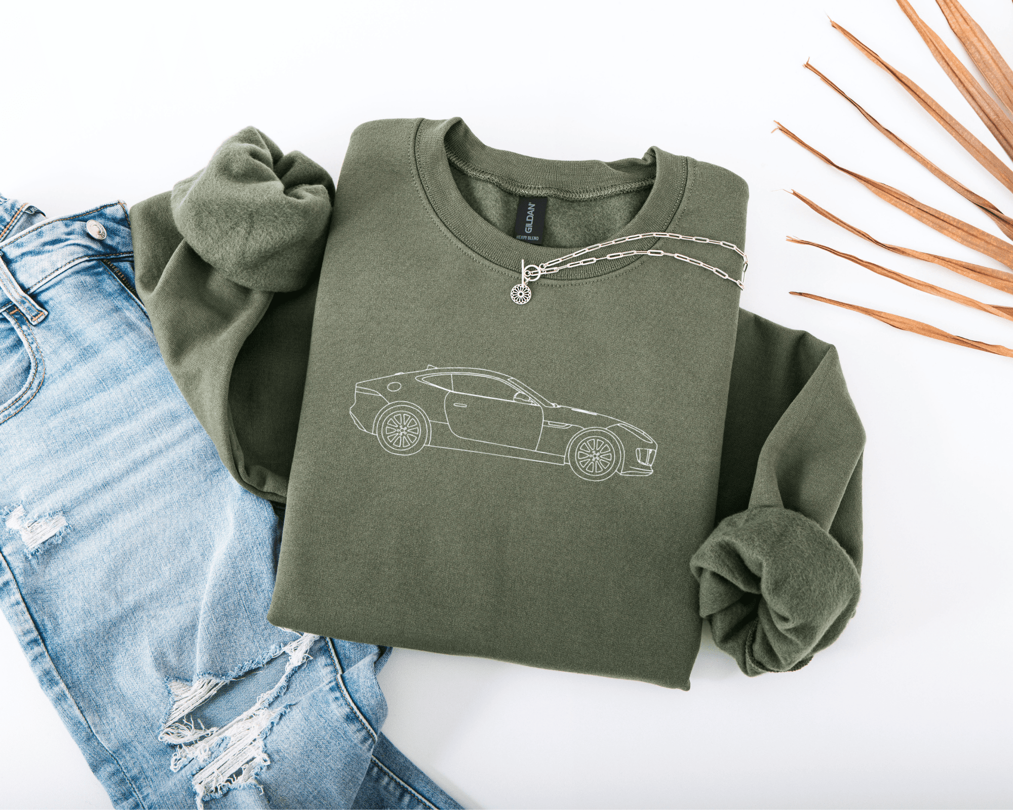 Green sweatshirt with car embroidered on a white background