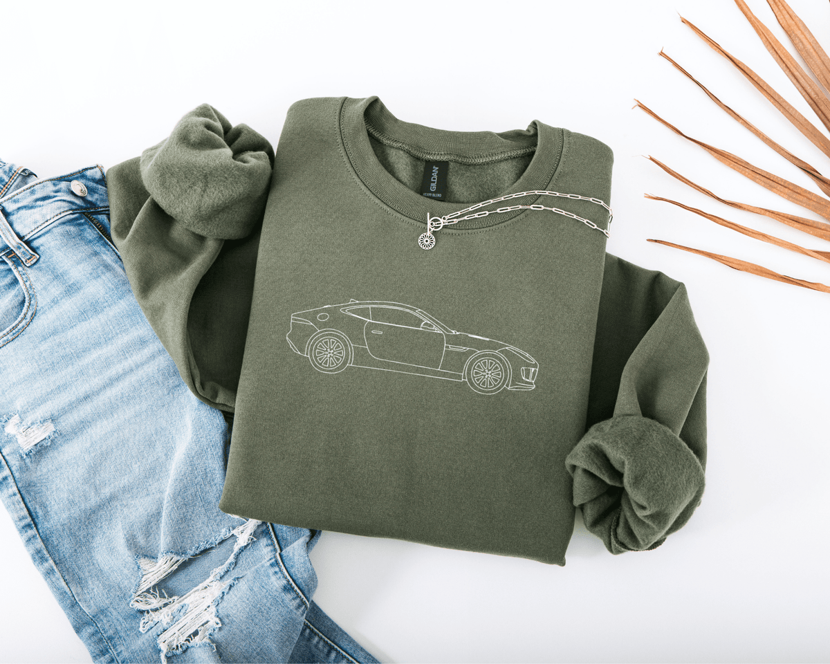 Green sweatshirt with car embroidered  on a white background