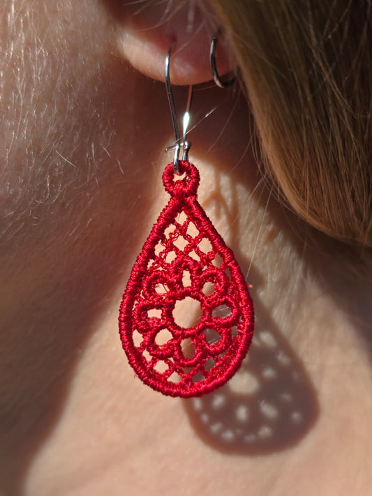 Red lace earring worn on an ear